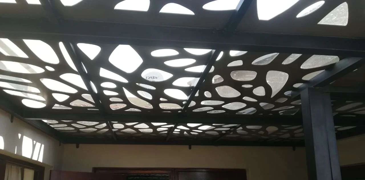 Daylight pouring through a laser cut ceiling panel over a patio